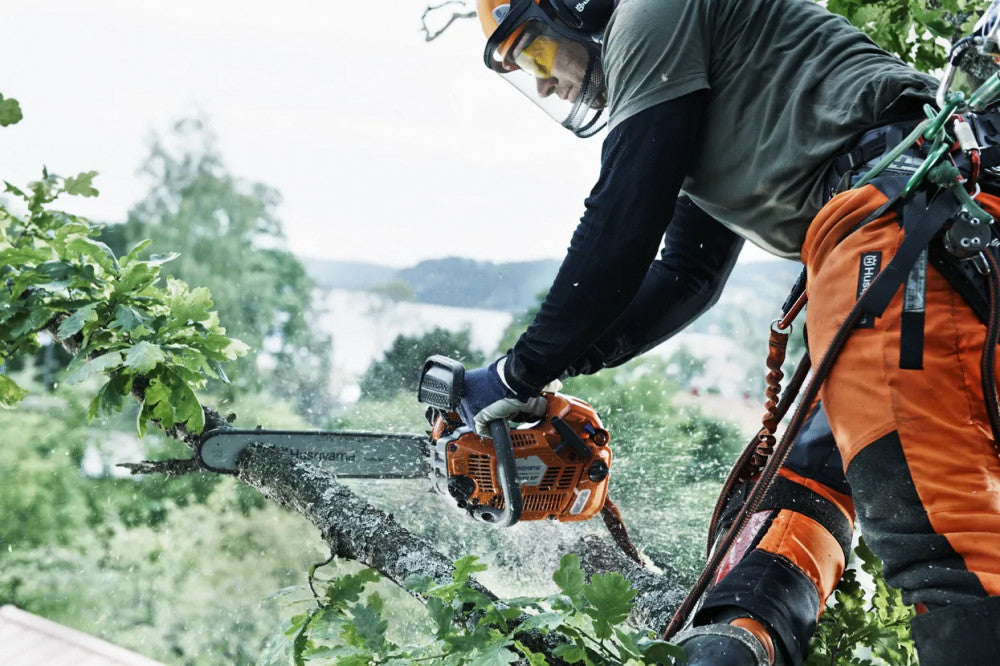 Husqvarna T540 XP II láncfűrésszel dolgozó arborista magasban, kötélbiztosítással
