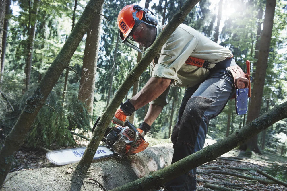 Husqvarna 562 XP láncfűrésszel rönköt daraboló favágó erdőben