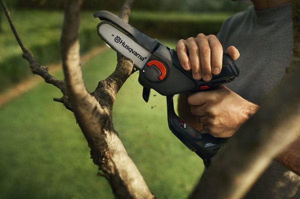 Husqvarna Aspire™ P5-P4A Kit metszőfűrész használat közben a kertben