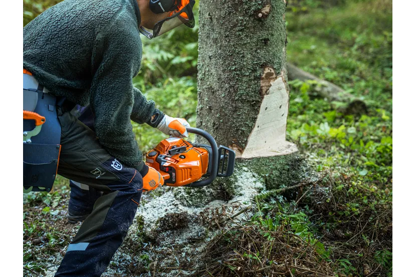 Husqvarna 450X láncfűrésszel dolgozó felhasználó erdőben